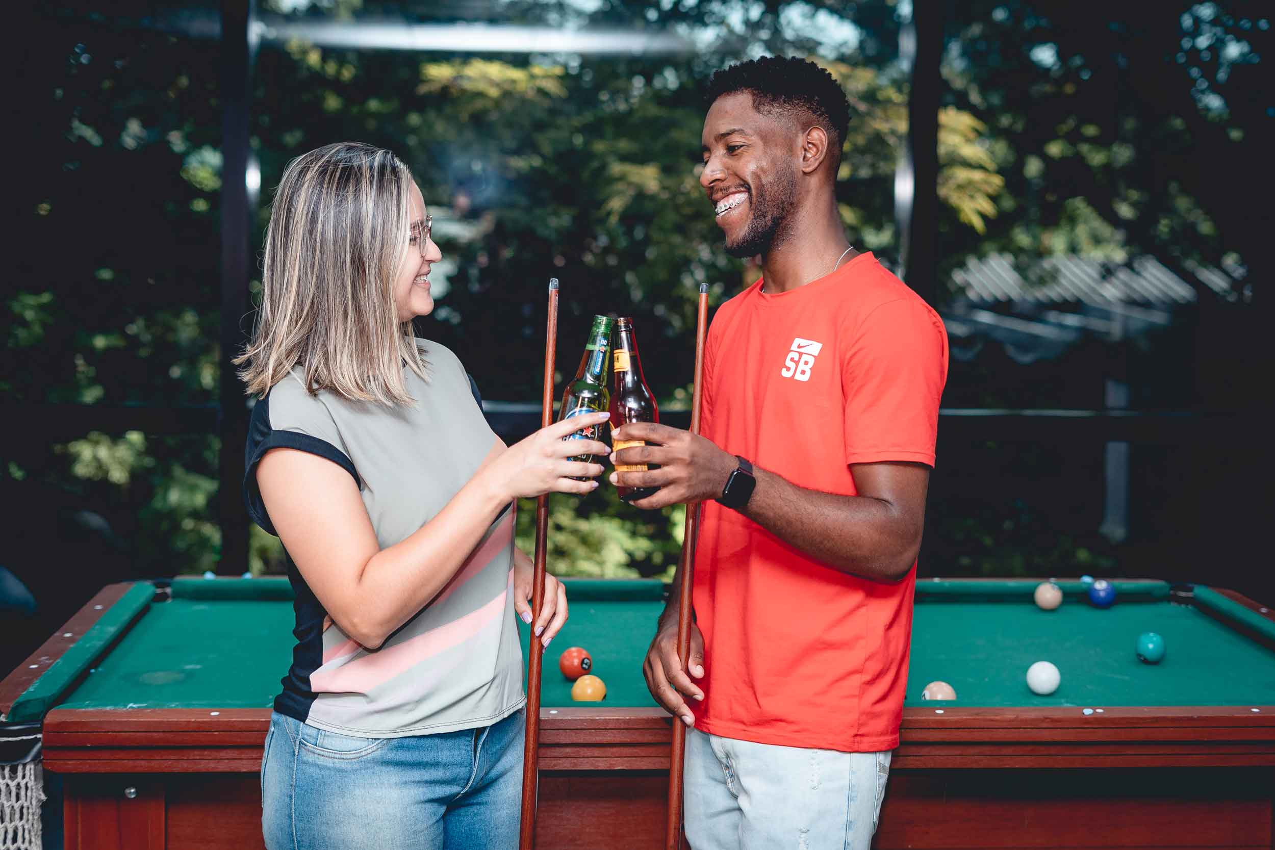 Brinde de cerveja com uma sinuca no fundo 